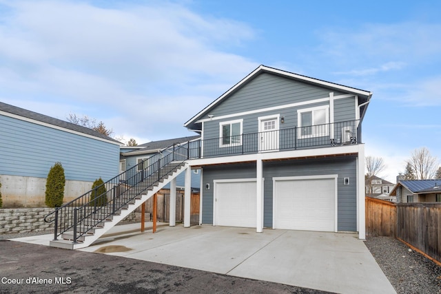 1006 E Garden Ave, Coeur Dalene, ID 83814 - beach home featuring stairway, a balcony, driveway, an attached garage, and fence
