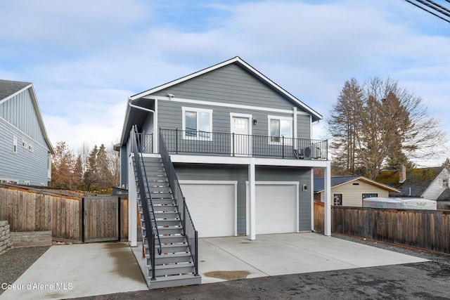 1006 E Garden Ave, Coeur Dalene, ID 83814 - view of front of property with a balcony, concrete driveway, fence, a garage, and stairs