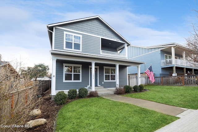 1006 E Garden Ave, Coeur Dalene, ID 83814 - traditional-style house with a front lawn, covered porch, fence, a balcony, and board and batten siding