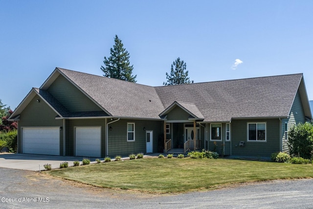 view of front of home with a front lawn, concrete driveway, a garage, and a shingled roof