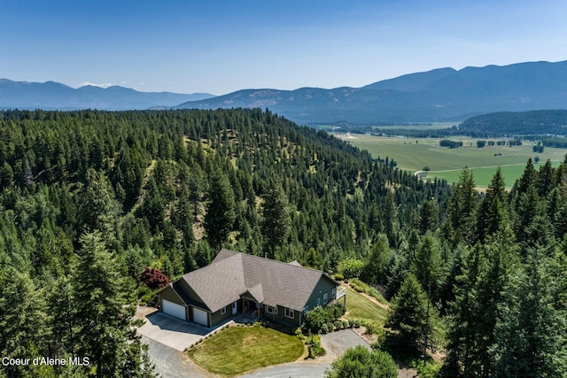 birds eye view of property with a mountain view and a wooded view