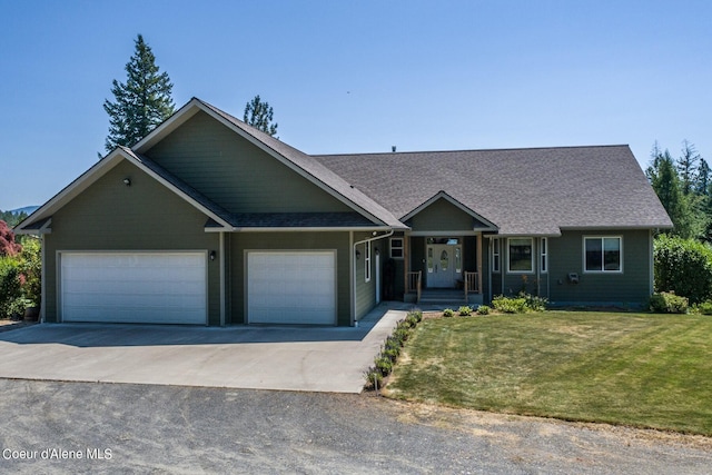 view of front of house with a front yard, concrete driveway, a garage, and roof with shingles