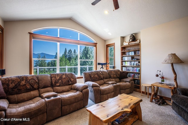 living area with baseboards, lofted ceiling, light carpet, a textured ceiling, and a ceiling fan