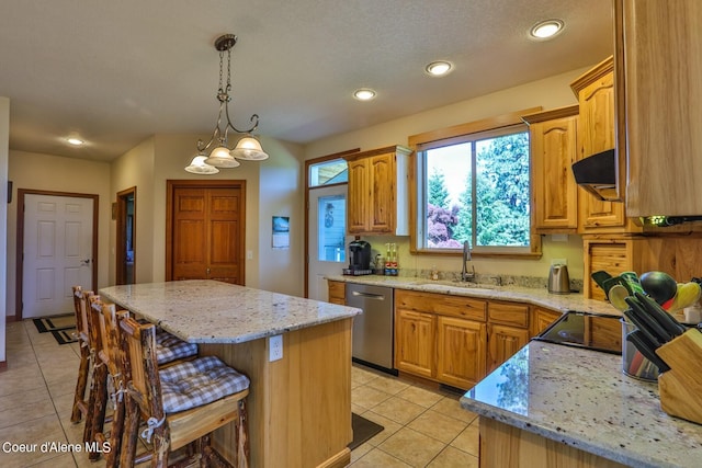 kitchen with a kitchen bar, a sink, light stone counters, under cabinet range hood, and dishwasher
