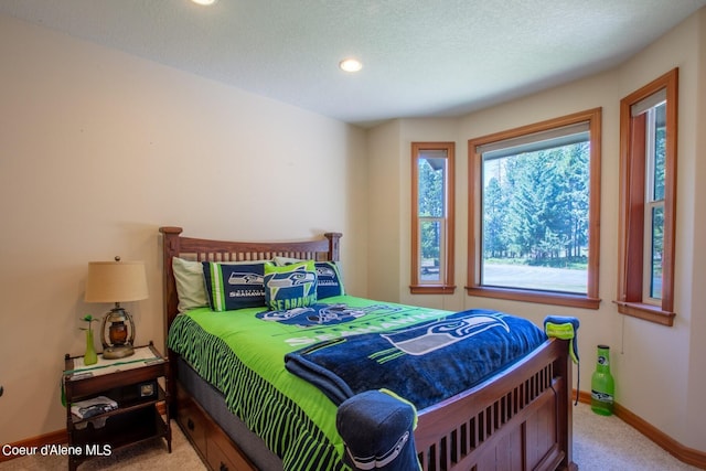 carpeted bedroom with recessed lighting, baseboards, and a textured ceiling