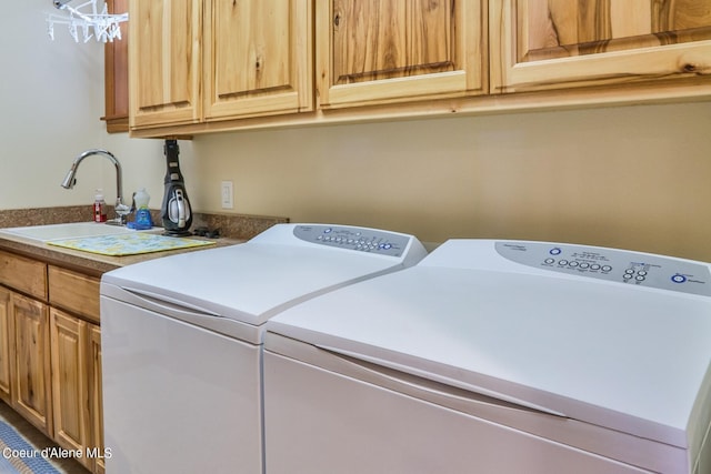 clothes washing area featuring a sink, cabinet space, and washer and clothes dryer