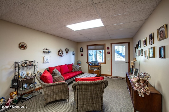 carpeted living room featuring baseboards and a paneled ceiling