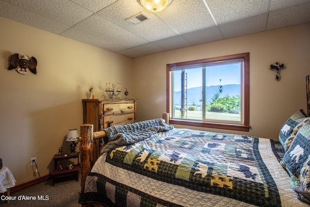 bedroom with visible vents, baseboards, a paneled ceiling, and carpet