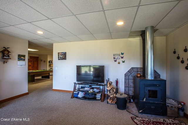 living area with billiards, a wood stove, carpet flooring, and baseboards