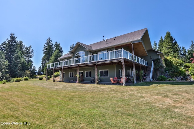 rear view of house with a deck, stairway, and a lawn