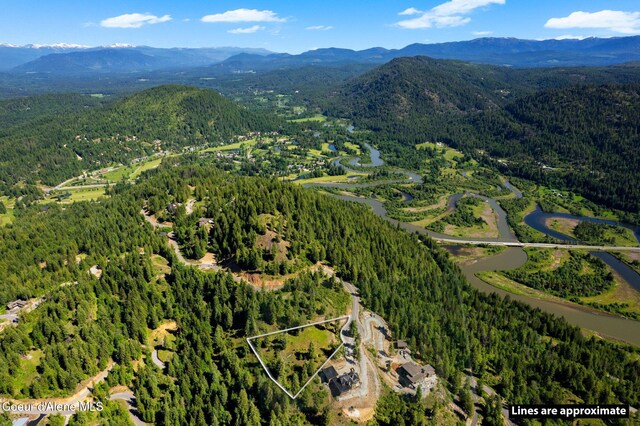 TBBT2 Green Monarch Ln, Sandpoint, ID 83864 - aerial view of property's location featuring a heavily wooded area, a mountain backdrop, and property boundaries highlighted