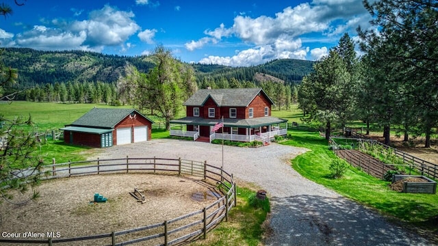 415 Shale Rd, Priest River, ID 83856 - view of front of house with a mountain view, an outbuilding, driveway, a garage, and a wooded view