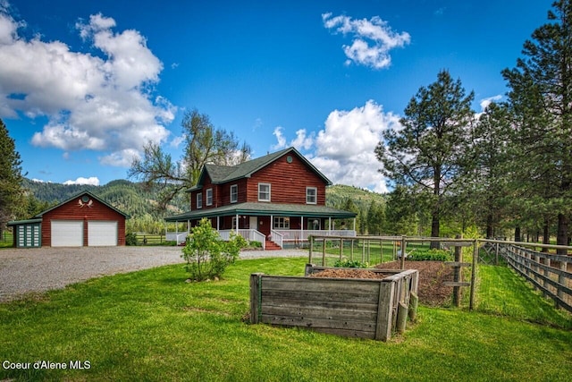 415 Shale Rd, Priest River, ID 83856 - rear view of house featuring covered porch, an outbuilding, driveway, and a garage