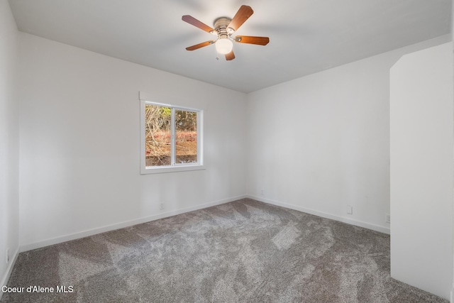 carpeted empty room featuring baseboards and a ceiling fan