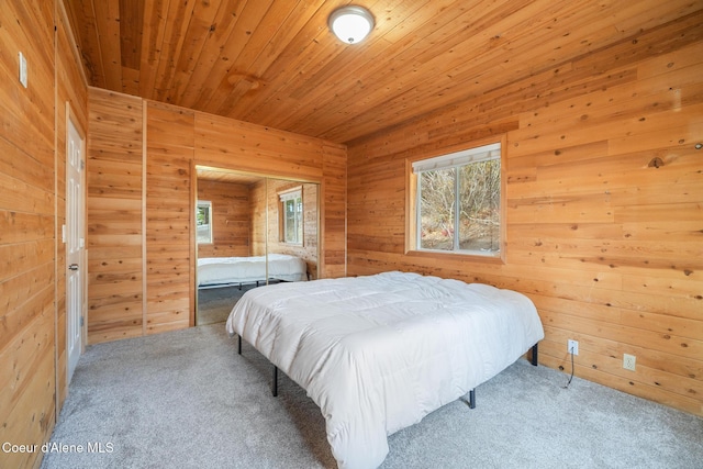 carpeted bedroom with wood walls and wood ceiling
