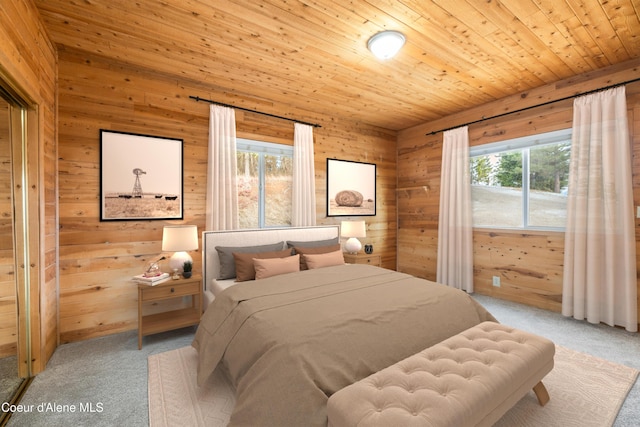 bedroom featuring wood walls, wood ceiling, and carpet
