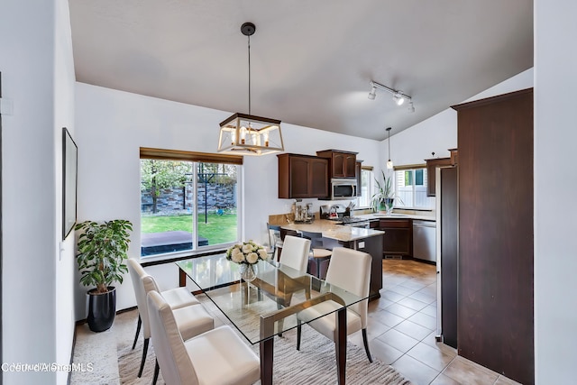 7068 N Epervier Ln, Coeur Dalene, ID 83815 - dining space featuring lofted ceiling, track lighting, a chandelier, healthy amount of natural light, and light tile patterned floors
