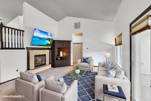 7068 N Epervier Ln, Coeur Dalene, ID 83815 - living area featuring a glass covered fireplace, high vaulted ceiling, and light carpet