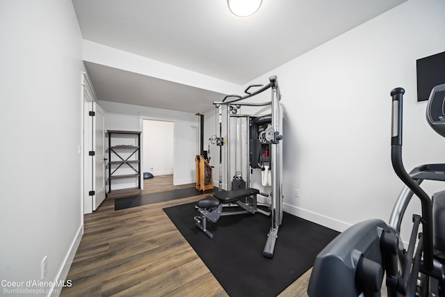 exercise room with baseboards and wood finished floors