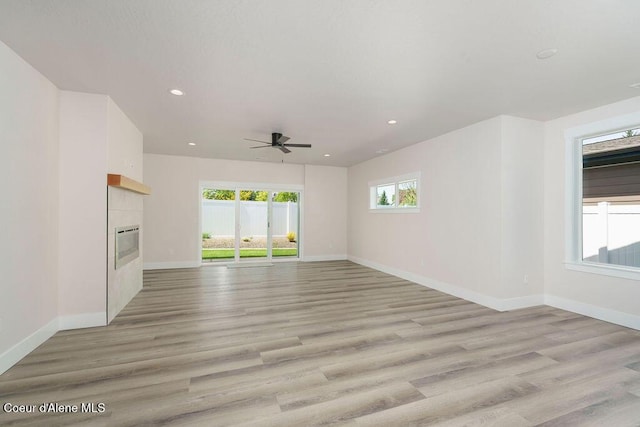 7365 N Breaux, Coeur Dalene, ID 83815 - unfurnished living room with a tile fireplace, a ceiling fan, baseboards, light wood-style floors, and recessed lighting