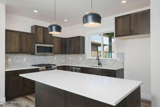 7365 N Breaux, Coeur Dalene, ID 83815 - kitchen with stainless steel appliances, a sink, wood finished floors, decorative backsplash, and dark brown cabinetry