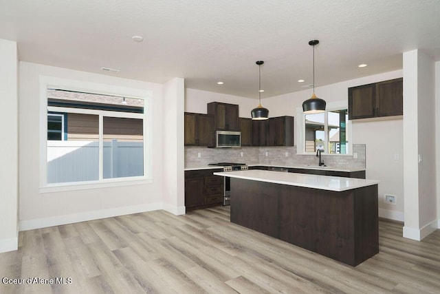 7365 N Breaux, Coeur Dalene, ID 83815 - kitchen with stainless steel appliances, a sink, dark brown cabinetry, light wood-style floors, and recessed lighting