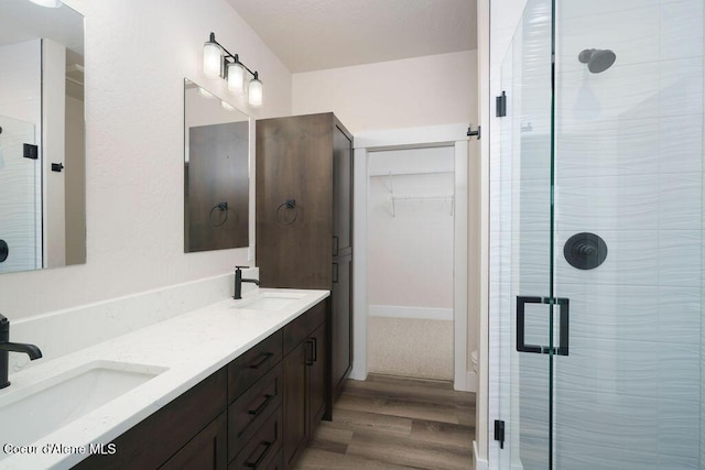 7365 N Breaux, Coeur Dalene, ID 83815 - full bathroom with wood finished floors, a stall shower, a walk in closet, and double vanity