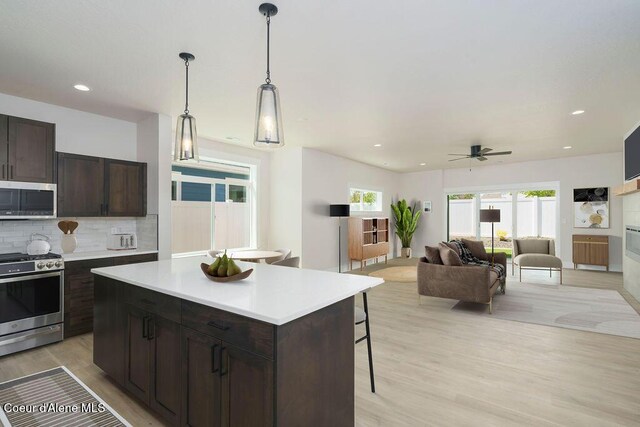 7279 N Grafton St, Coeur Dalene, ID 83815 - kitchen featuring stainless steel appliances, light countertops, ceiling fan, a kitchen bar, and light wood finished floors
