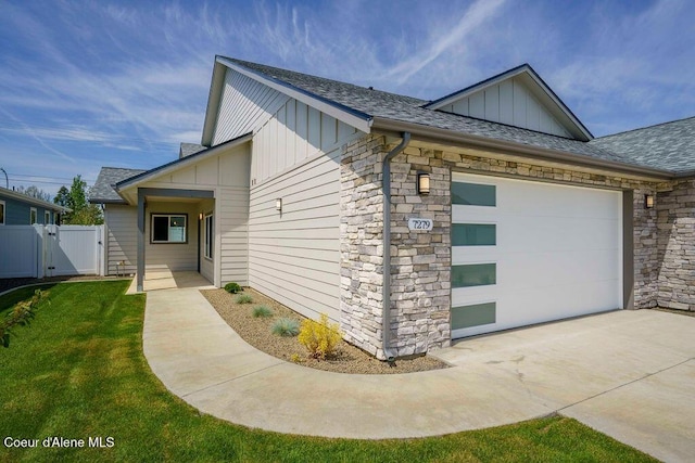 7279 N Grafton St, Coeur Dalene, ID 83815 - view of side of property featuring board and batten siding, concrete driveway, a gate, an attached garage, and a shingled roof