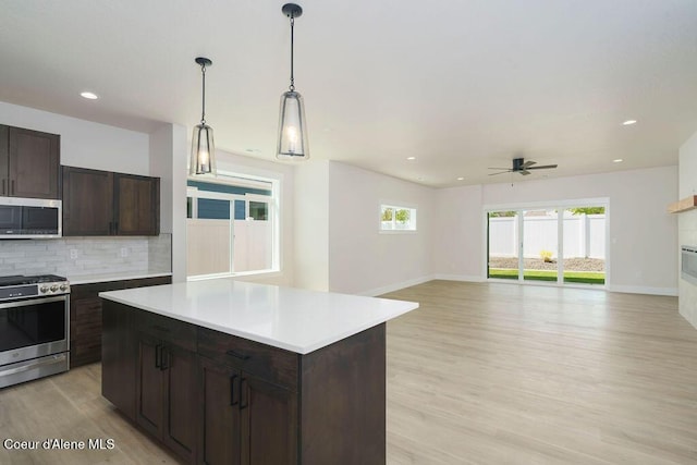 7279 N Grafton St, Coeur Dalene, ID 83815 - kitchen with stainless steel appliances, light wood-style flooring, backsplash, a ceiling fan, and light countertops