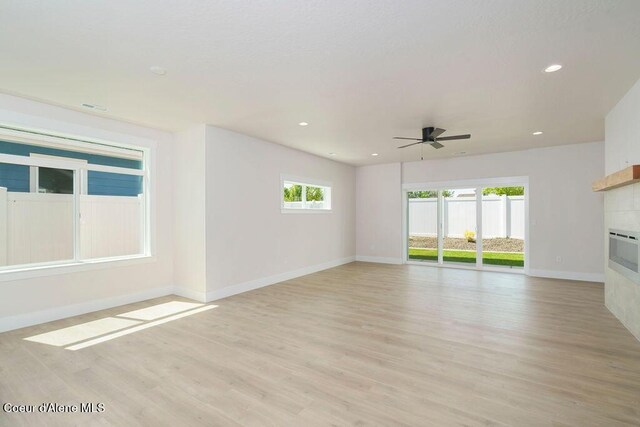 7279 N Grafton St, Coeur Dalene, ID 83815 - unfurnished living room with a tiled fireplace, a ceiling fan, baseboards, light wood-type flooring, and recessed lighting