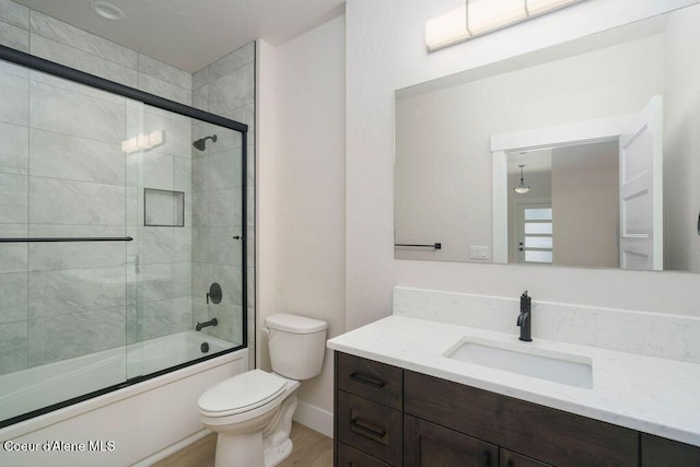 7279 N Grafton St, Coeur Dalene, ID 83815 - bathroom featuring toilet, wood finished floors, shower / bath combination with glass door, vanity, and baseboards