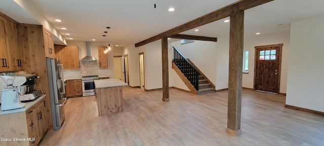 kitchen featuring wall chimney range hood, decorative backsplash, appliances with stainless steel finishes, a center island, and recessed lighting