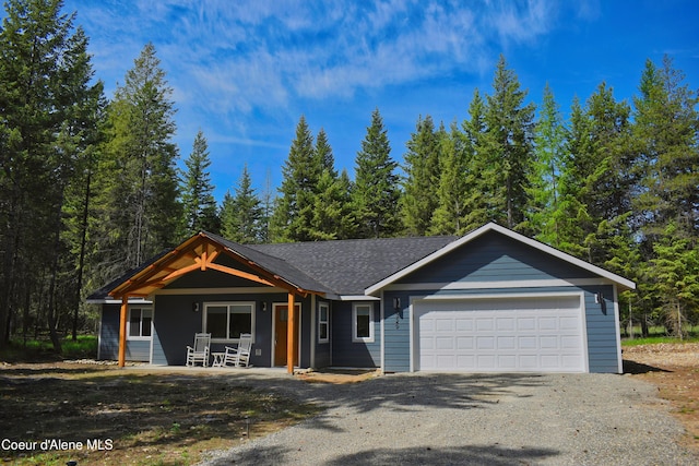 view of front of home with a garage, driveway, and covered porch
