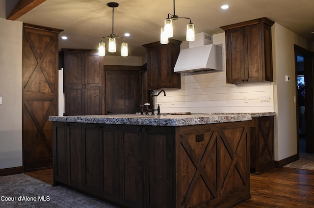 kitchen featuring baseboards, dark brown cabinetry, custom range hood, and dark wood-style floors