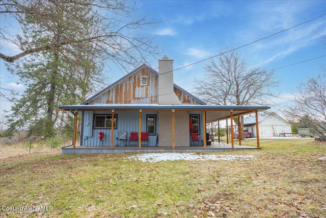 farmhouse with a front yard, board and batten siding, a porch, and a chimney