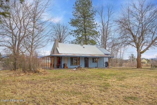view of front of home with a front lawn, metal roof, and a porch