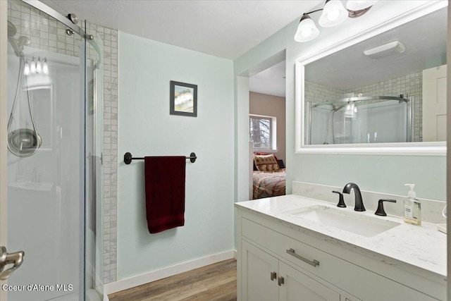 bathroom with a shower stall, wood finished floors, vanity, and ensuite bath