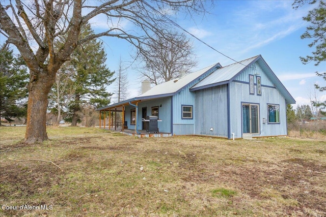 exterior space featuring a lawn, a chimney, and a porch