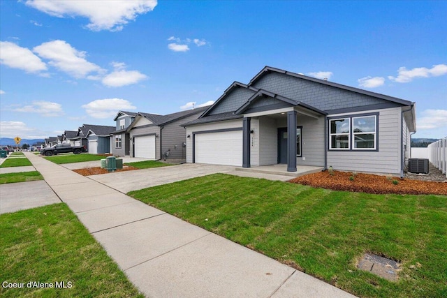 view of front of house with a front yard, a garage, cooling unit, a residential view, and driveway