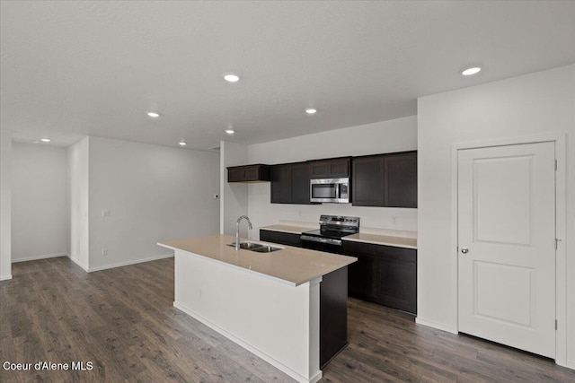 kitchen featuring a sink, dark wood-style flooring, light countertops, appliances with stainless steel finishes, and recessed lighting