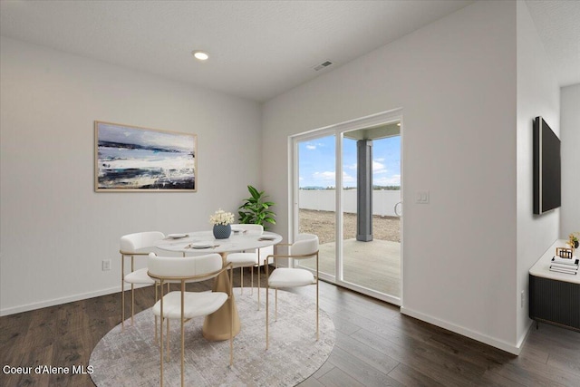 dining area featuring visible vents, baseboards, and wood finished floors