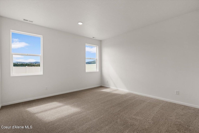 carpeted spare room with recessed lighting, visible vents, baseboards, and a textured ceiling