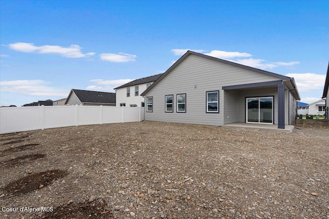 rear view of house with a patio area and fence