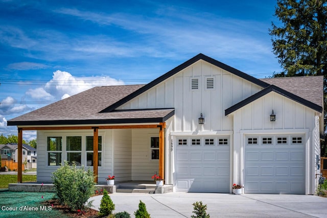 1690 Irvine Way, Sandpoint, ID 83864 - view of front of property featuring a shingled roof, a porch, a garage, concrete driveway, and board and batten siding