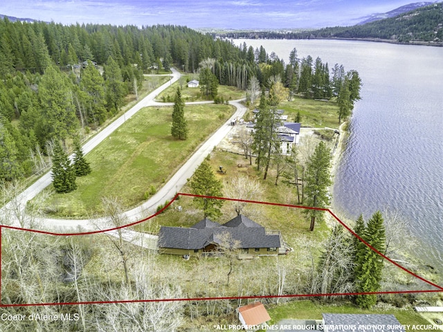 aerial view with a water view and a wooded view