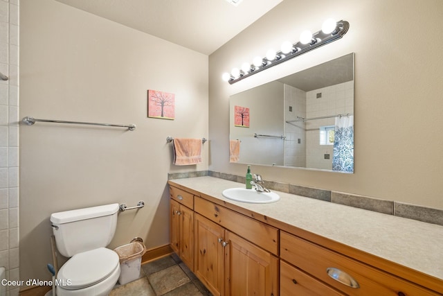 4459 E Ogara Rd, Harrison, ID 83833 - bathroom with toilet, tiled shower, baseboards, and vanity