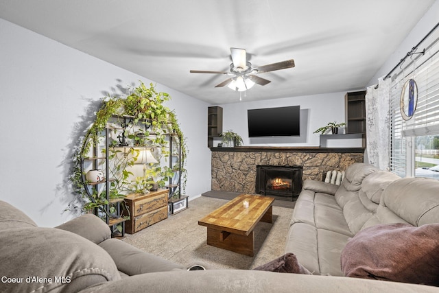 living room featuring ceiling fan, carpet floors, and a fireplace