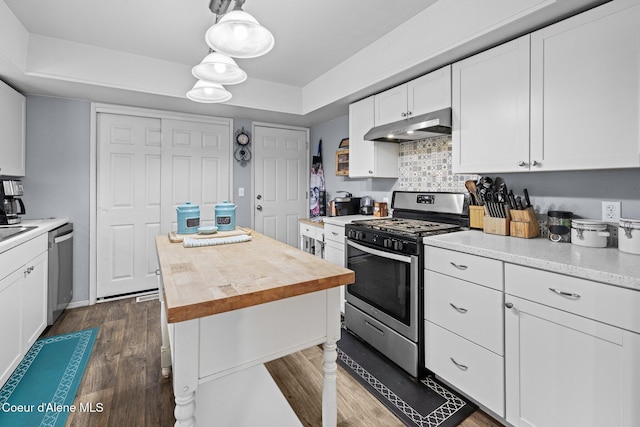 kitchen with stainless steel appliances, under cabinet range hood, wood counters, white cabinetry, and dark wood finished floors