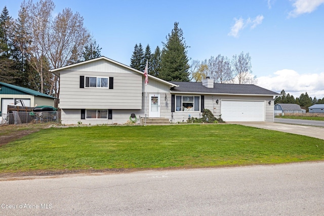 tri-level home featuring driveway, a chimney, and a garage